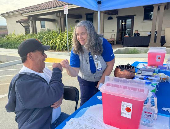 Man fist bumps nurse