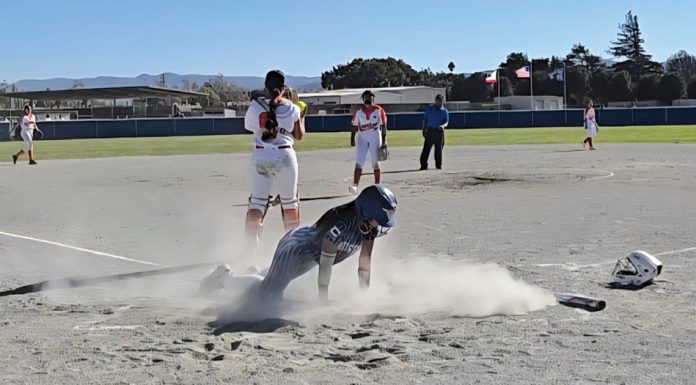 Softball player slides home