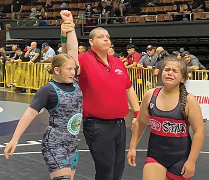Gonzales wrestler hand raised after winning