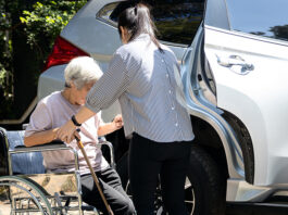 Greenfield awarded transportation grant for senior voucher system caregiver helping disabled elderly woman in wheelchair to get into the car