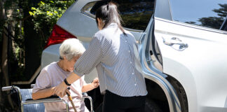 Greenfield awarded transportation grant for senior voucher system caregiver helping disabled elderly woman in wheelchair to get into the car