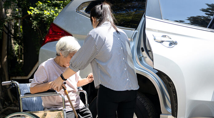 Greenfield awarded transportation grant for senior voucher system caregiver helping disabled elderly woman in wheelchair to get into the car