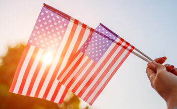 Woman holding USA flag celebrating Independence Day