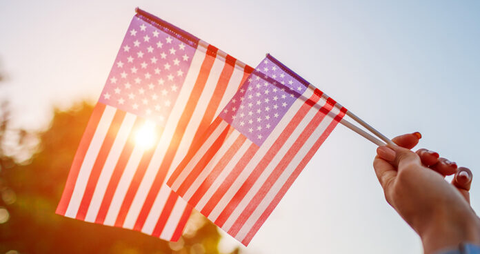 Woman holding USA flag celebrating Independence Day
