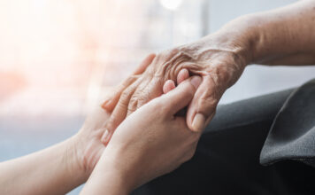 Parkinson disease patient, Alzheimer elderly senior, Arthritis person hand in support of nursing family caregiver care for disability awareness day