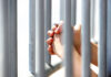 Federal grant extends youth violence prevention program in Monterey County Hands Grasping Metal Bars in Light