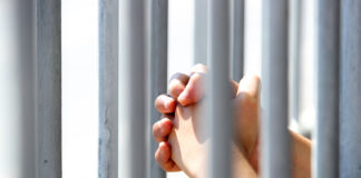 Federal grant extends youth violence prevention program in Monterey County Hands Grasping Metal Bars in Light